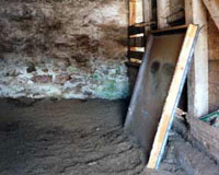 The uninstalled framed glass picture window stored inside the bank barn with Anastasia.